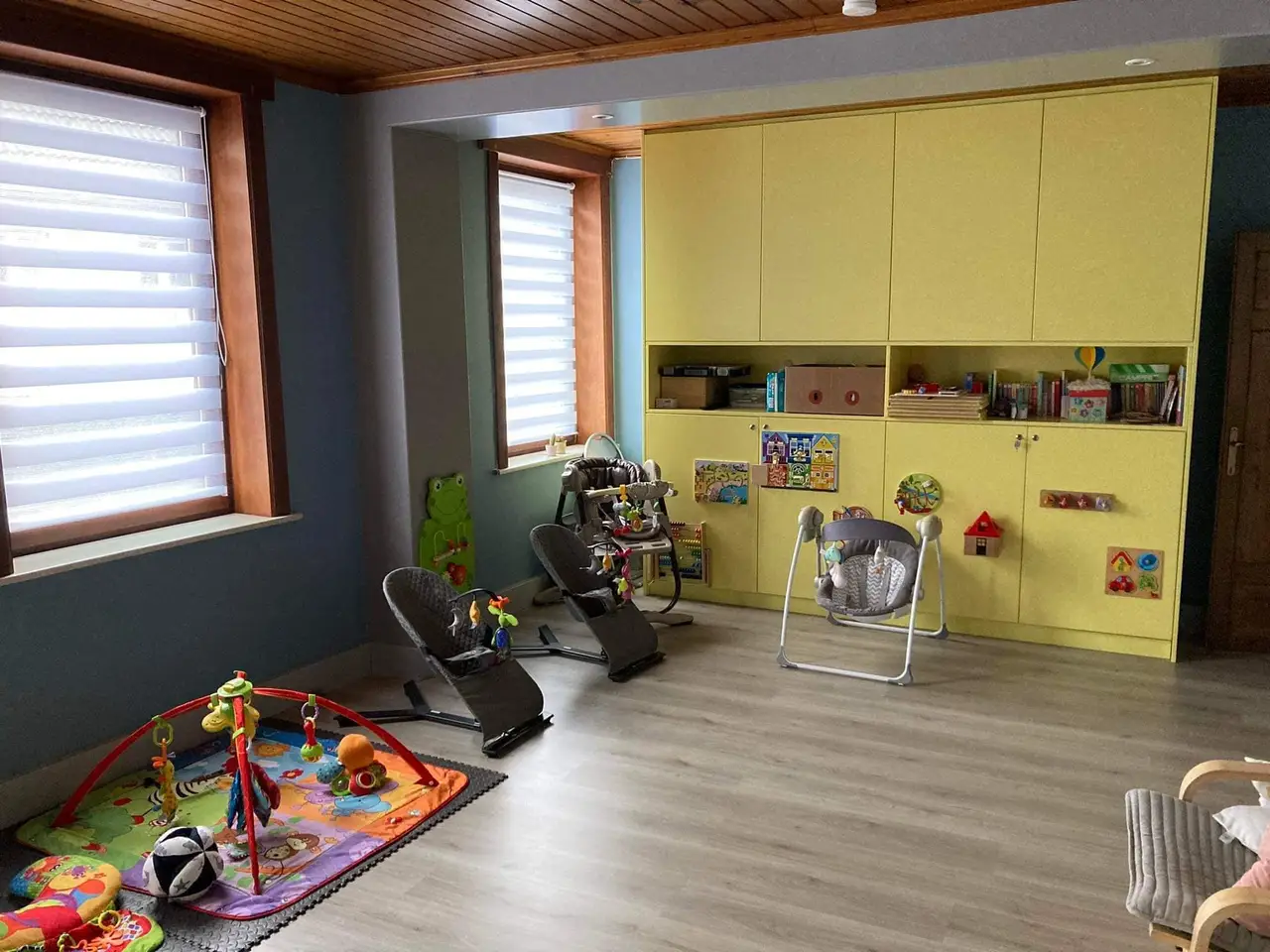 Salle de jeux avec grand meuble jaune et fenêtre en bois