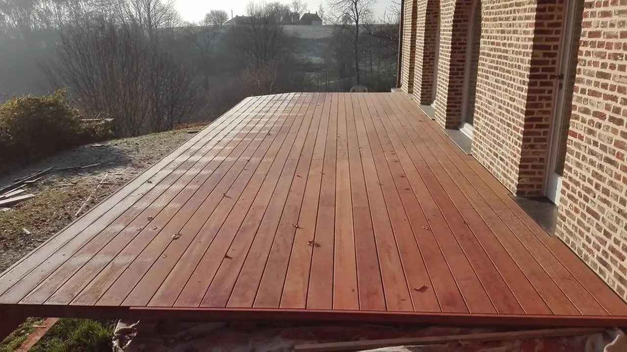 Terrasse en lames de bois posée le long d’un mur en briques