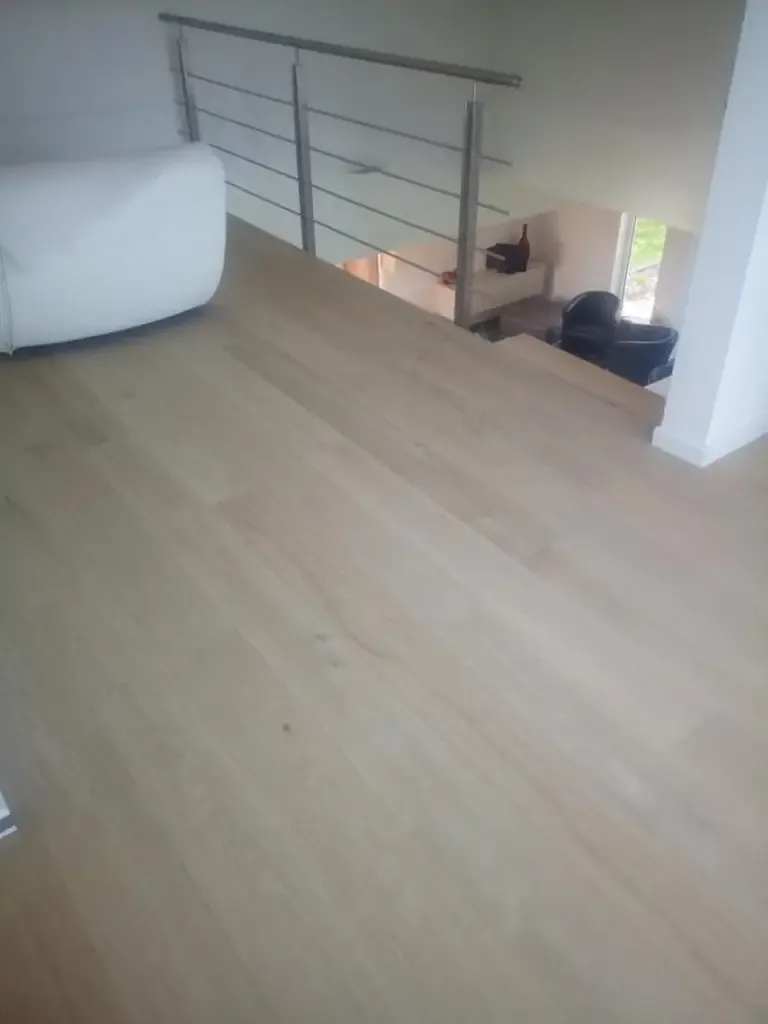 Parquet en chêne clair sur un palier ouvert avec garde-corps métallique à barres horizontales